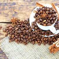 Buy canvas prints of Grain coffee in a cup on a wooden background. Cinnamon on a napkin and tied with string. Anise stars complement the aroma of coffee. by Sergii Petruk