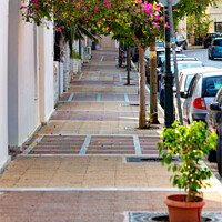 Buy canvas prints of Deserted old sidewalk on Loutraki street in Greece on an early summer morning. by Sergii Petruk