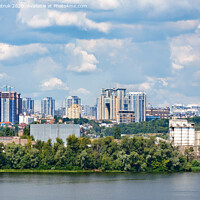 Buy canvas prints of The beautiful cityscape of Kyiv with the Dnipro River, an industrial complex on the bank and new high-rise buildings on the horizon. by Sergii Petruk