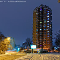 Buy canvas prints of High-rise apartment building against the background of a city street in a winter city evening park covered with snow against a background of blue twilight. by Sergii Petruk