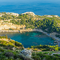 Buy canvas prints of Overlooking Anthony Quinn Bay by Ian Woolcock