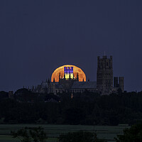 Buy canvas prints of Strawberry Moon rising behind Ely Cathedral, 14th June 2022 by Andrew Sharpe