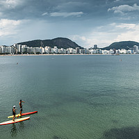 Buy canvas prints of Two men on a Stand Up Paddle on Copacabana Beach,  by Alexandre Rotenberg