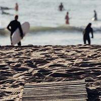 Buy canvas prints of Wooden boards on beach leading to surfers on water by Alexandre Rotenberg