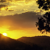 Buy canvas prints of Sunset sun behind the mountain with orange sky by Juan Ramón Ramos Rivero