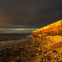 Buy canvas prints of Hunstanton Cliffs at sunset with dark stormy sky by Andrew Michael