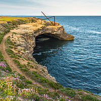 Buy canvas prints of Stone quarry crane above sea cave by Andrew Michael