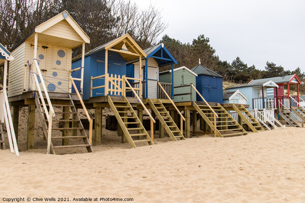 Beach huts above the sand Picture Board by Clive Wells
