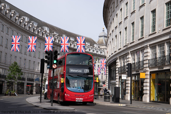London bus under the flags Picture Board by Clive Wells
