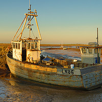 Buy canvas prints of Fishing boat grounded at Brancaster Staith by Clive Wells