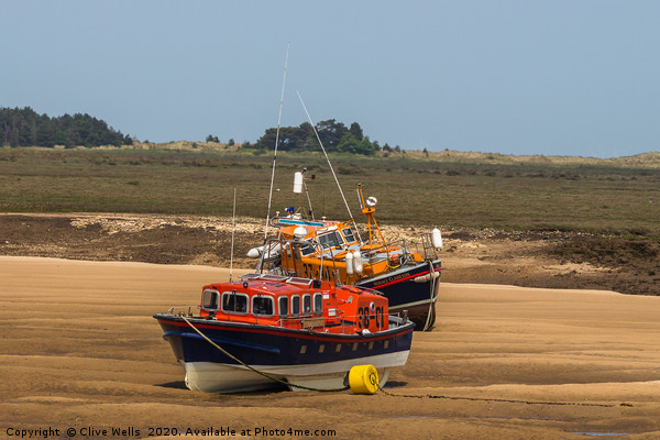 Lifeboats on the mud flats at Wells-Next-Sea Picture Board by Clive Wells