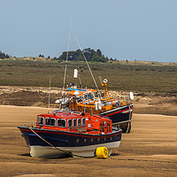 Buy canvas prints of Lifeboats on the mud flats at Wells-Next-Sea by Clive Wells