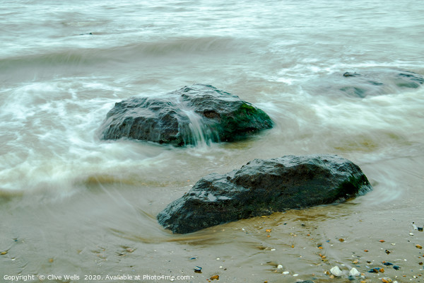 Incoming tide on the rocks at Old Hunstanton Picture Board by Clive Wells