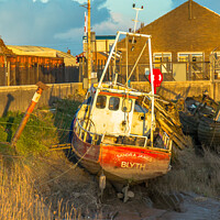 Buy canvas prints of Small fishing boat stuck on the mud by Clive Wells