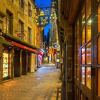Buy canvas prints of Looking up Grand Rue, Mont Saint Michel at night by Lenscraft Images