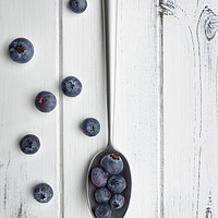 Buy canvas prints of blueberries and a silver spoon on distressed white by Phill Thornton