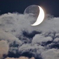 Buy canvas prints of Cloudy Crescent Moon with Earthshine by Susan Snow