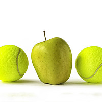 Buy canvas prints of Yellow apple between two tennis balls by Rosaline Napier