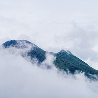 Buy canvas prints of Arenal Volcano peaking through clouds by Chris Rabe