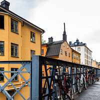 Buy canvas prints of Bicycles parked in the street with colorful houses in Sodermalm  by Juan Jimenez