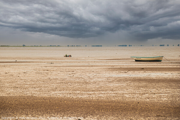 Norfolk coast with storm in the back over the sea boats moored on the sandy beach  Picture Board by Holly Burgess