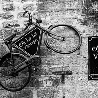 Buy canvas prints of French Elegance: Vintage Bicycle Against Brick Fac by Holly Burgess