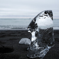 Buy canvas prints of Clear piece of glacial ice on black sand by Lensw0rld 