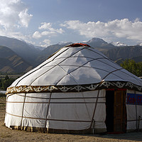 Buy canvas prints of Yurt in front of a mountain range in Kyrgyzstan by Lensw0rld 