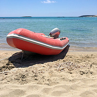 Buy canvas prints of Red rubber boat at Elafonisi beach in Crete by Lensw0rld 