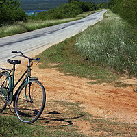 Buy canvas prints of Retro bike next to an empty road in Cuba by Lensw0rld 