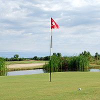 Buy canvas prints of golf course with red flag and ball by goce risteski