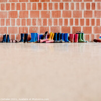 Buy canvas prints of Rubber rain boots on the floor at the entrance to a college clas by Joaquin Corbalan