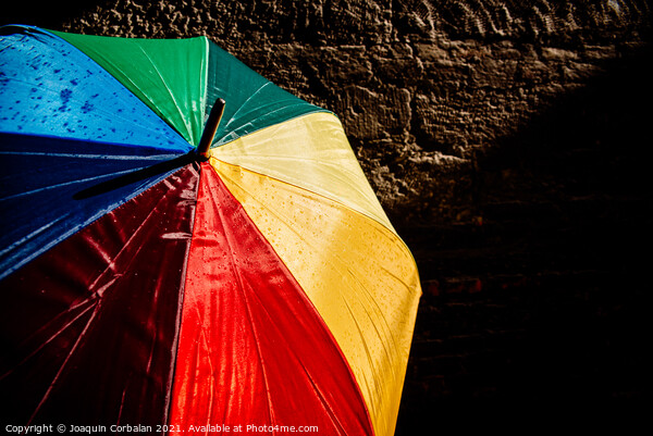 Open umbrella against the intense sun with bright colors and dar Picture Board by Joaquin Corbalan