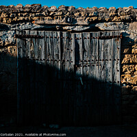 Buy canvas prints of Old and decrepit wooden gate, half lit by the sun, in an unpopul by Joaquin Corbalan