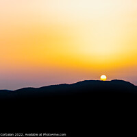 Buy canvas prints of The hot sun hides behind the mountains on a summer day at dusk. by Joaquin Corbalan