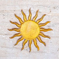 Buy canvas prints of The drawing of a sun with golden rays engraved on marble on a wa by Joaquin Corbalan