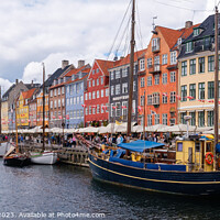 Buy canvas prints of Copenhagen, Denmark - August 8, 2023: The most famous canal in Copenhagen with its quaint colorful houses overlooking the docked sailboats. by Joaquin Corbalan