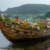 Buy canvas prints of A viking boat filled with colorful flowers gently glides on the calm lake waters. by Joaquin Corbalan
