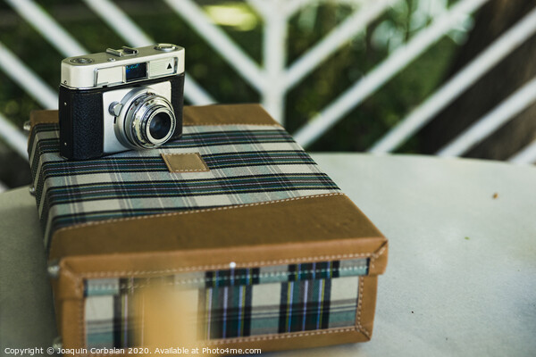 Old analog photo camera on a vintage travel suitcase. Picture Board by Joaquin Corbalan