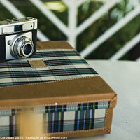 Buy canvas prints of Old analog photo camera on a vintage travel suitcase. by Joaquin Corbalan
