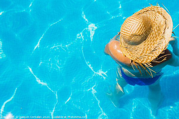 Woman in a pool with hat relaxed and rested. Picture Board by Joaquin Corbalan