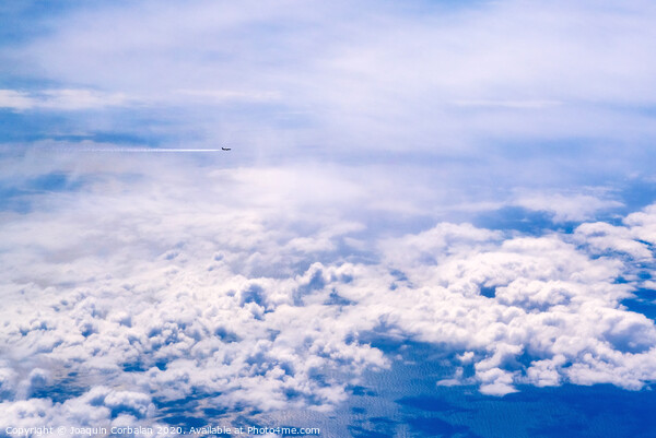 Plane of commercial flights crossing a sky of blue and white clouds seen from above, on the Mediterranean. Picture Board by Joaquin Corbalan