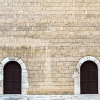 Buy canvas prints of High stone walls with two symmetrical doors, medieval stone background. by Joaquin Corbalan