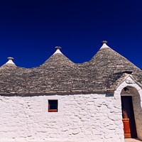 Buy canvas prints of Stone tiles cover the roofs of the trulli in Alberobello, an Italian city to visit on a trip to Italy. by Joaquin Corbalan