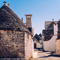 Buy canvas prints of Stone tiles cover the roofs of the trulli in Alberobello, an Italian city to visit on a trip to Italy. by Joaquin Corbalan