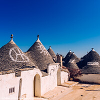 Buy canvas prints of Alberobello, Italy - March 9, 2019:  Roofs with symbols in the trulli, in the famous Italian city of Alberobello. by Joaquin Corbalan