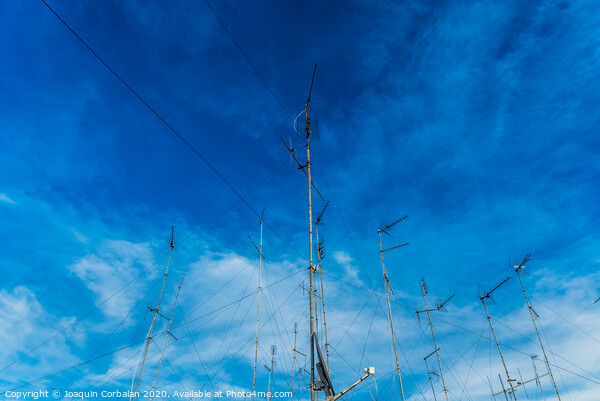 Television antennas on the roof of an old building with dramatic sky. Picture Board by Joaquin Corbalan