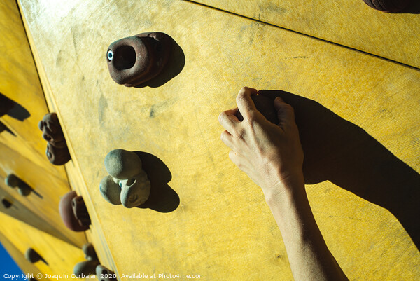 Hand of a person trying to climb the fixie of a climbing wall Picture Board by Joaquin Corbalan