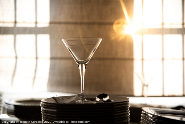 Empty glass cup with sun flares background in a restaurant. Picture Board by Joaquin Corbalan