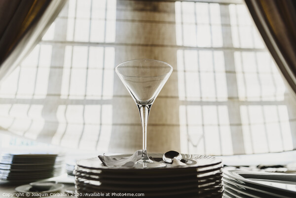 Empty glass cup with sun flares background in a restaurant. Picture Board by Joaquin Corbalan